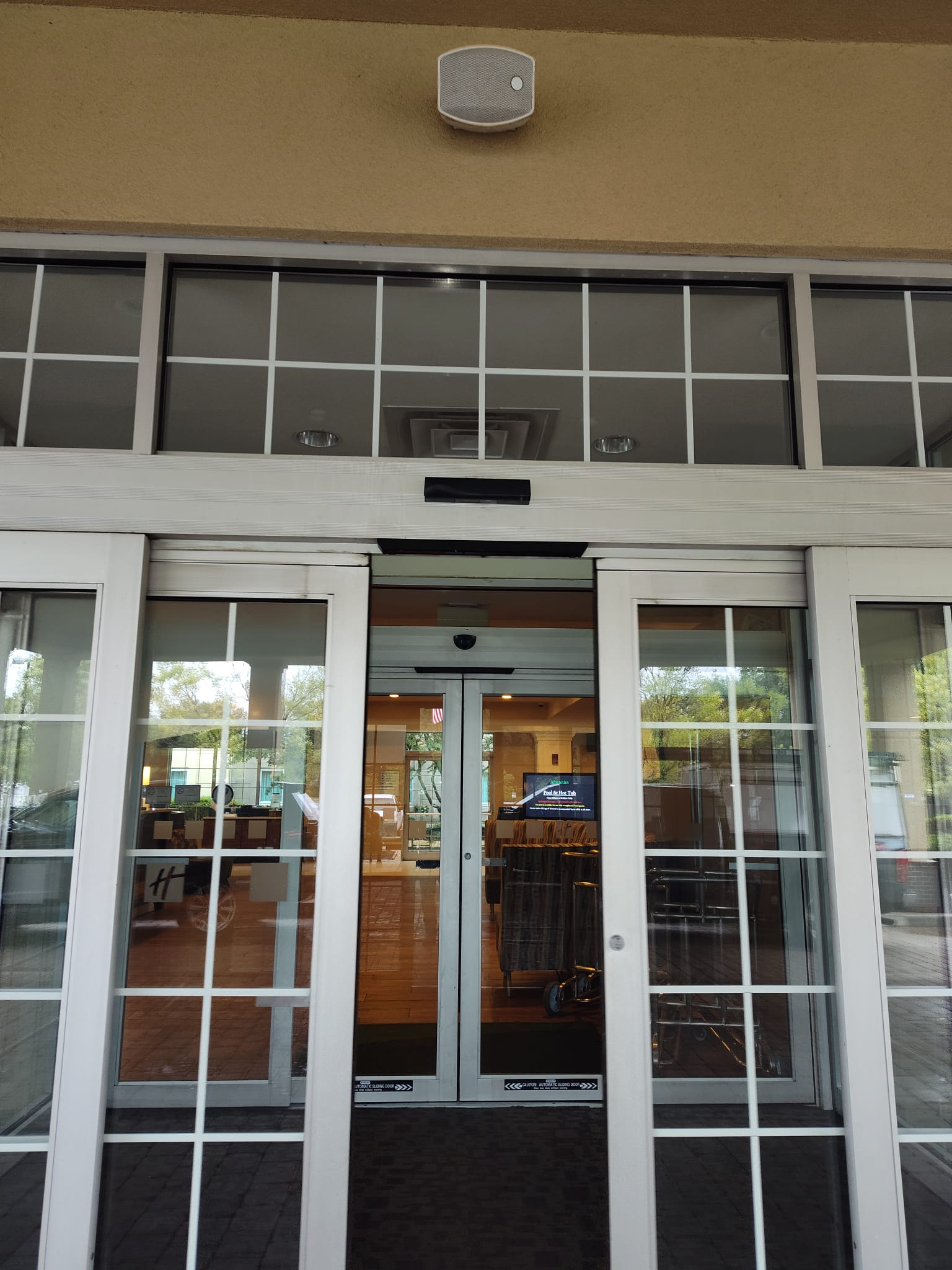 White-framed automatic glass entrance with divided sidelights